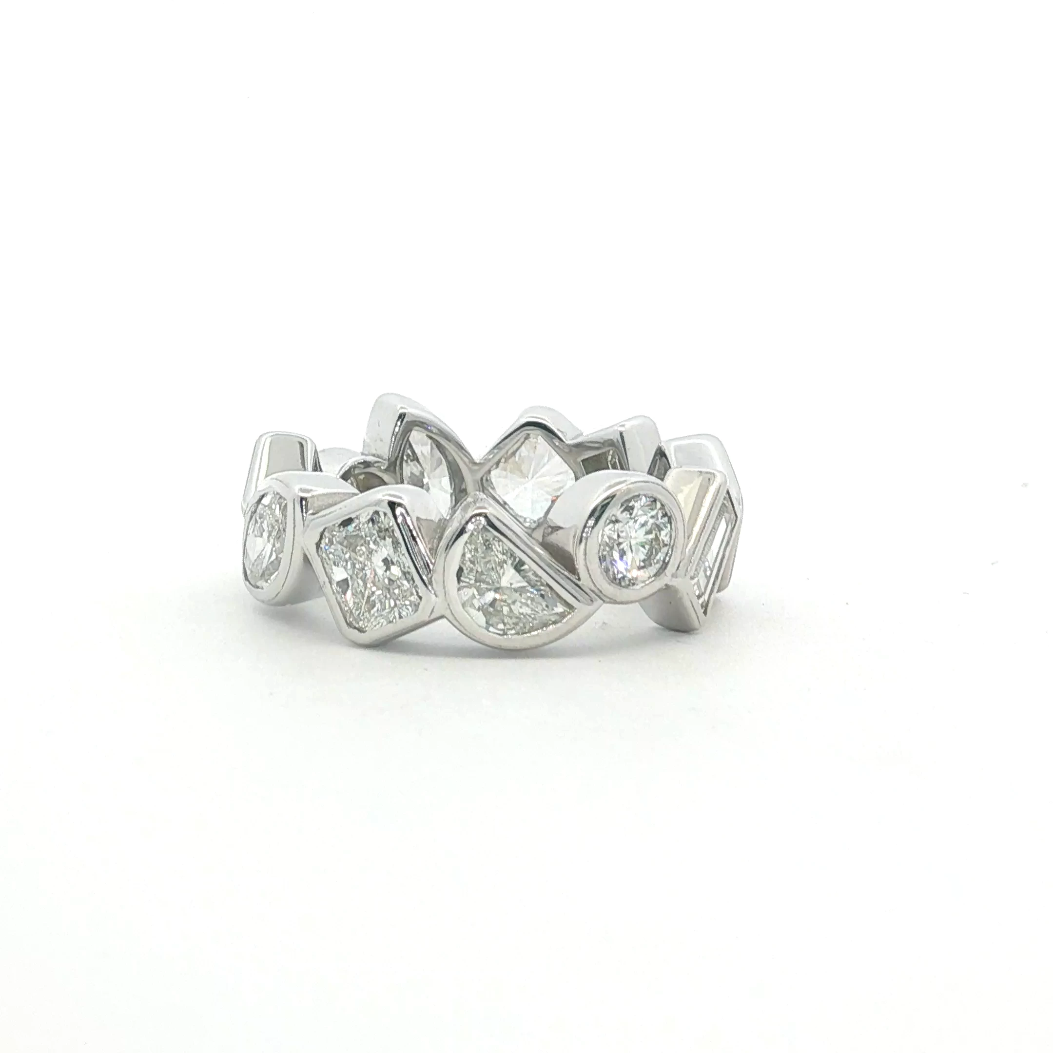This exquisite 14k white gold eternity ring showcases a continuous band of multi-shaped diamonds, meticulously set to ensure maximum light reflection. Each diamond features exceptional clarity and a high-grade polish, creating a seamless stream of radiance. The timeless composition and symmetrical arrangement highlight the precision of the brilliant cutting style. Designed with a sleek profile, this piece serves as a sophisticated symbol of everlasting elegance, perfect for stacking or as a standalone statement. Diamond weight- 5.60ct