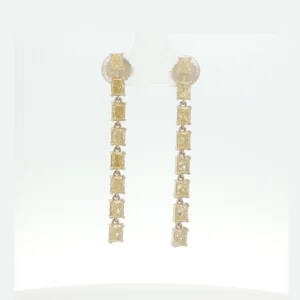 A continuous line of fancy intense yellow diamonds creates a striking silhouette in these linear dangle earrings. Each stone is articulated to allow graceful movement, securely set in a white gold framework.